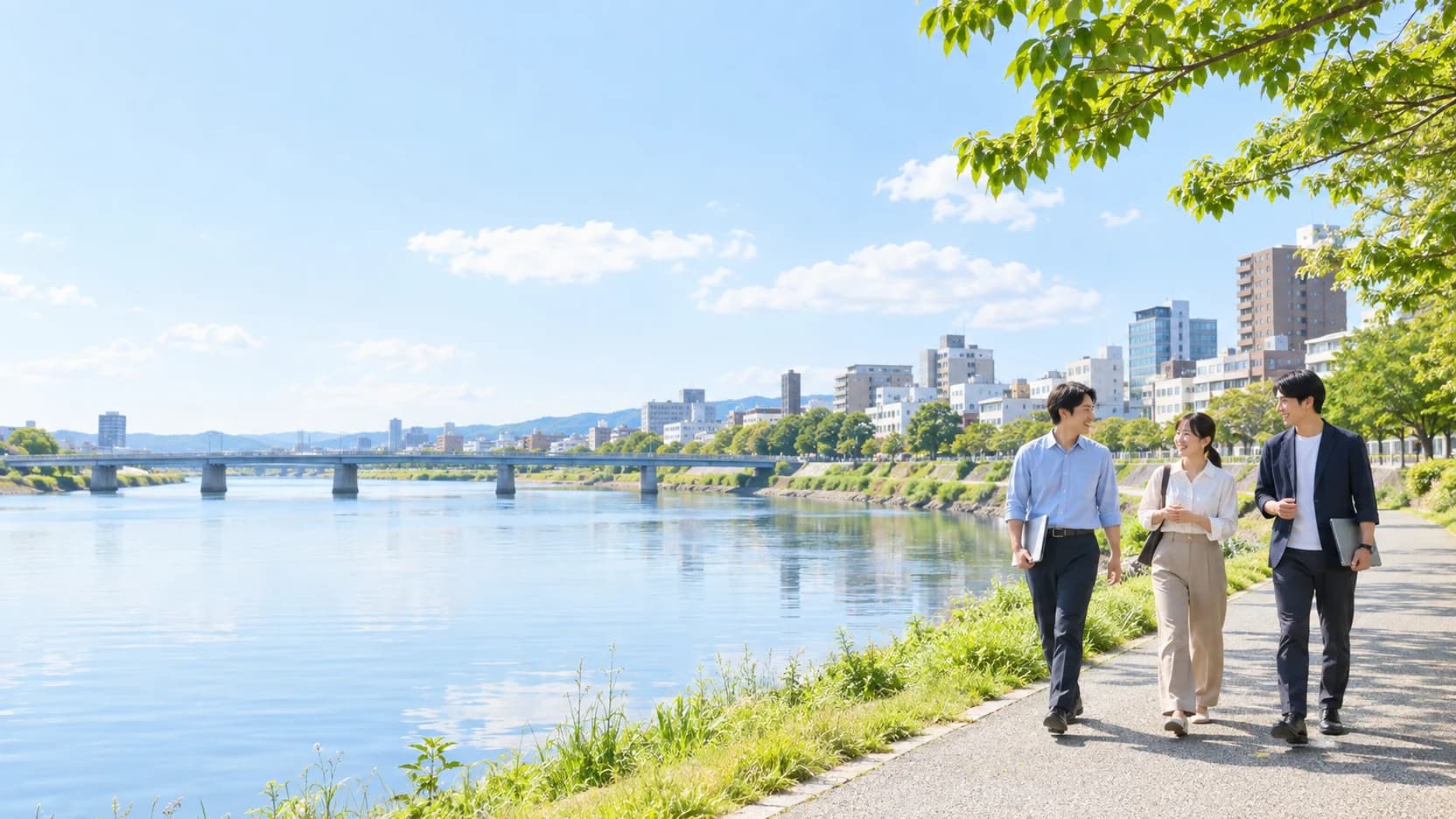 People walking along a riverside in a regional city with a river and bridges